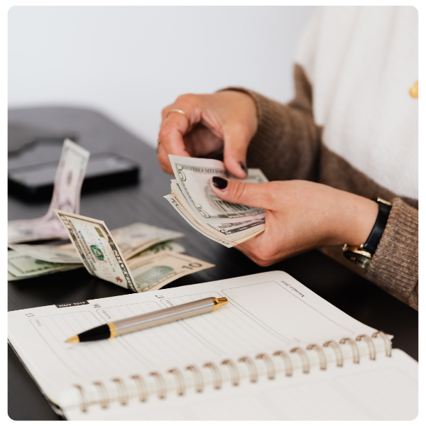 woman sitting at desk counting cash